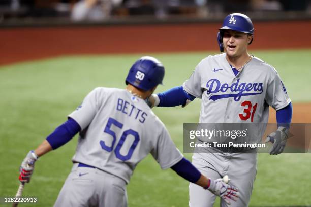 Joc Pederson of the Los Angeles Dodgers is congratulated by Mookie Betts after hitting a solo home run against the Tampa Bay Rays during the second...