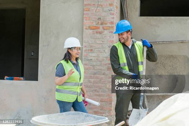 two professional construction workers talk outside the building - general view stock pictures, royalty-free photos & images