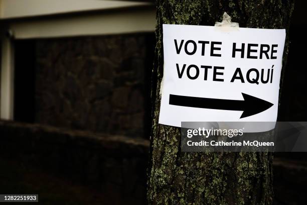 paper “vote here” sign affixed to tree at town voting precinct - election results stock-fotos und bilder