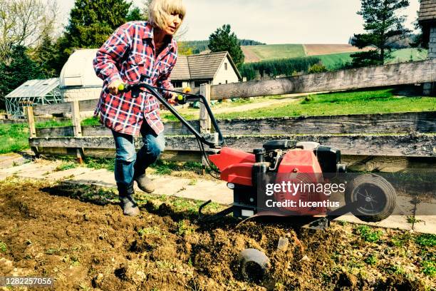 woman using a garden rotovator - harrow agricultural equipment stock pictures, royalty-free photos & images