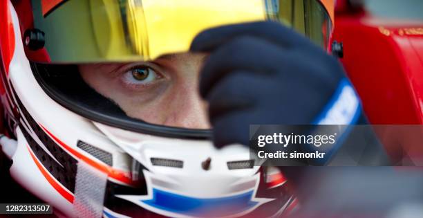 conductor con casco y guante de choque - piloto de coches de carrera fotografías e imágenes de stock