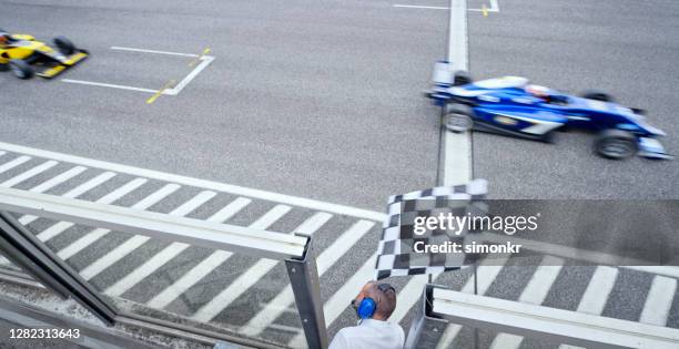 auto-rennen offiziell winken karierte flagge - zielflagge stock-fotos und bilder