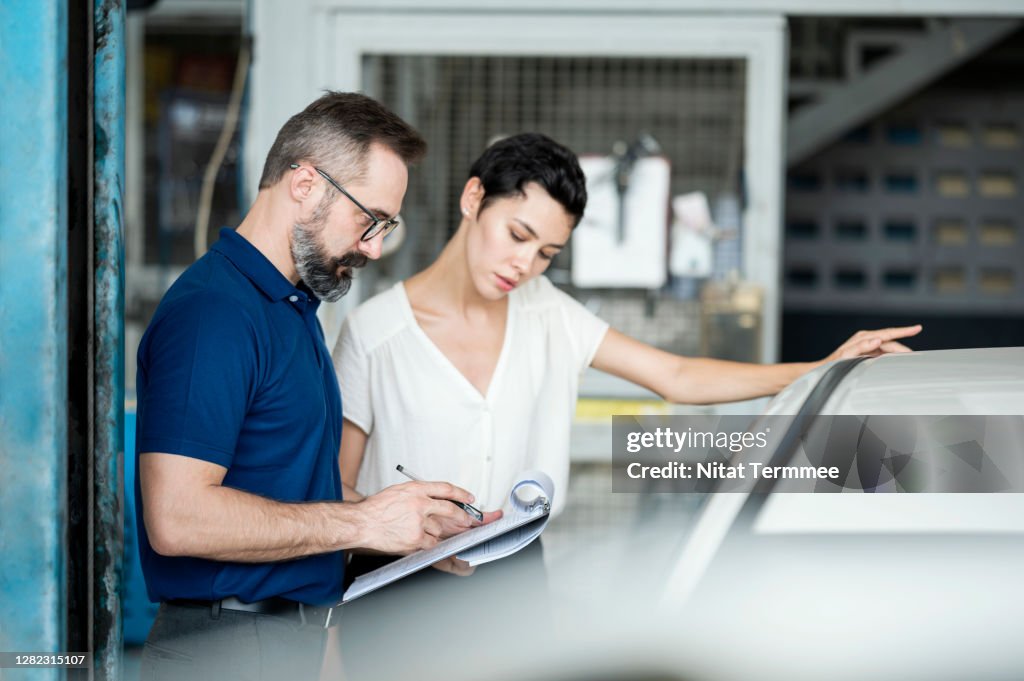 Car Insurance Claims. Insurance adjuster explaining damage of car exterior to customer at Auto Repair Center. Business hour 24/7 service coverage. Customer Service, Quality of Service.