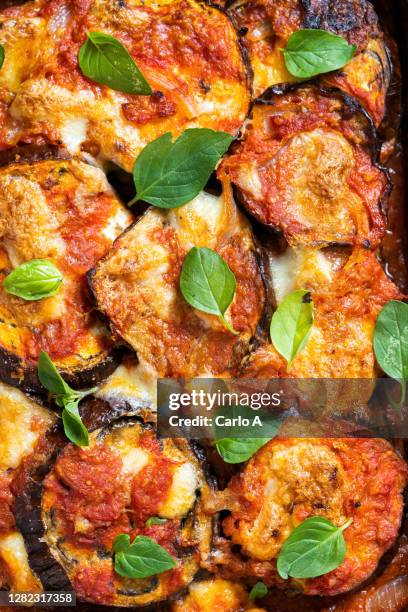 extreme close up of baked eggplants with cheese and tomato sauce, also called parmigiana. - melanzana foto e immagini stock