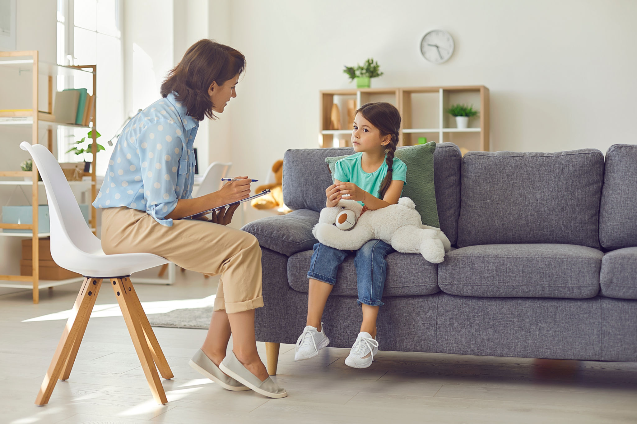 Female child psychologist working with a little preschool girl in a bright office. Female child psychologist working with a little preschool girl in a bright office.