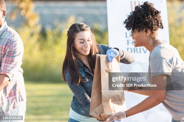 female friends volunteer together during food drive - giving tuesday stock pictures, royalty-free photos & images