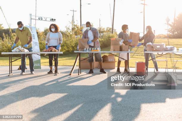 voluntários trabalham em food drive ao ar livre - food drive - fotografias e filmes do acervo