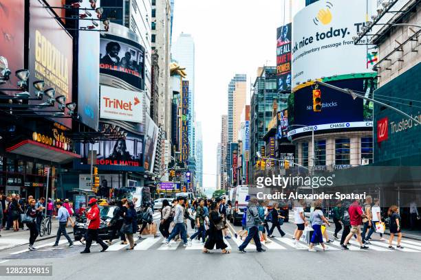 crowds of people on the street in new york city, ny, usa - new york city stock-fotos und bilder