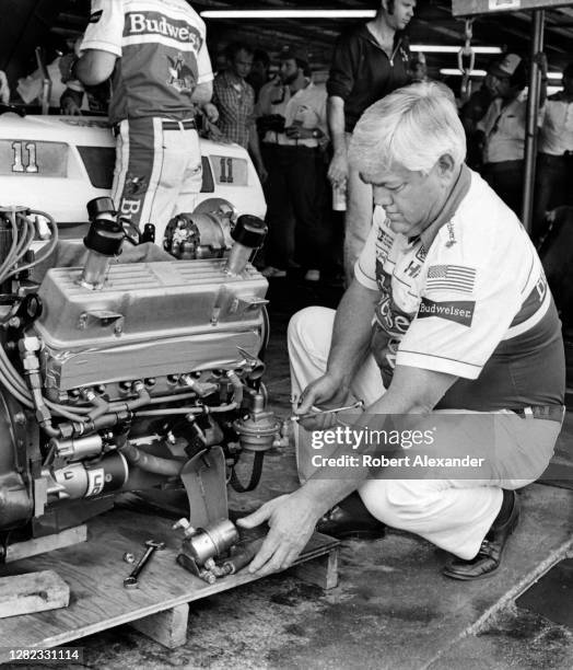 Legendary NASCAR driver and racecar owner Junior Johnson works on the engine which will be installed in his racecar prior to the start of the 1985...