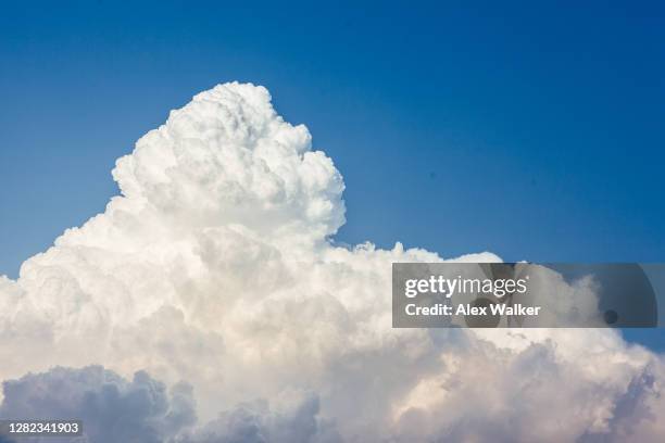 large cumulonimbus clouds against blue sky with aircraft - cumulonimbus fotografías e imágenes de stock