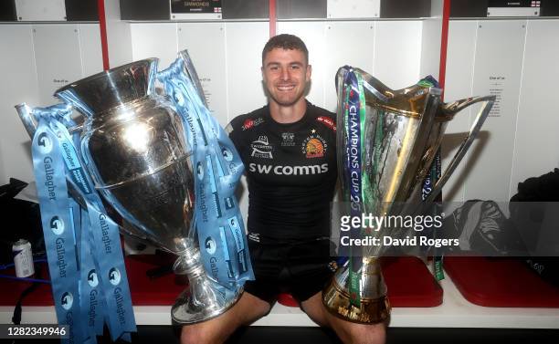 Ollie Devoto of Exeter Chiefs poses with the Gallagher Premiership trophy and the European Champions Cup after their victory during the Gallagher...