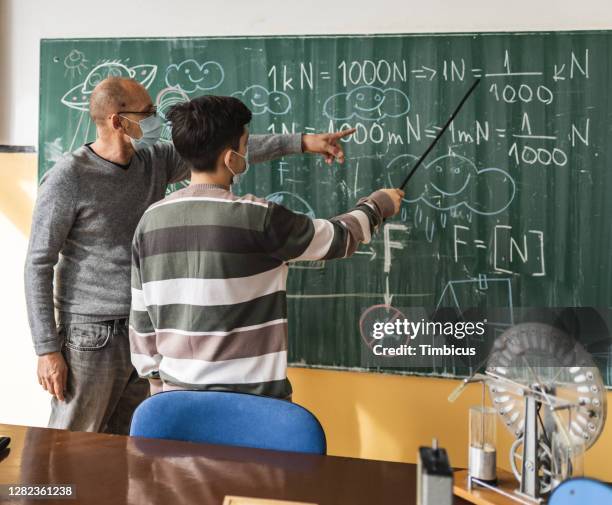 professor unterrichtet seinen studenten physik an der schule in der zeit des corona-virus - physics stock-fotos und bilder