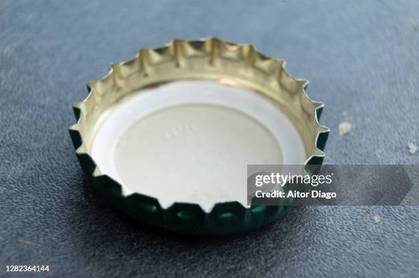 close up of a bottle cap on a table. - beer cap stock pictures, royalty-free photos & images