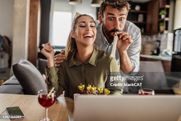 pareja celebrando el cumpleaños en una videollamada en casa - cat with red hat fotografías e imágenes de stock