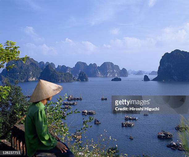 man in hat looking over ha long bay, quang ninh province, vietnam - baie d'halong photos et images de collection