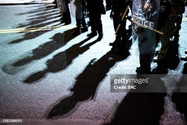 scudi della polizia e ombre contro la protesta degli attivisti - dimostrazione di protesta foto e immagini stock