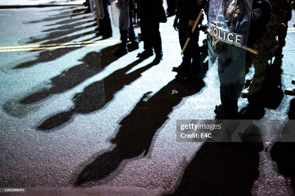 Escudos da polícia e sombras em protesto ativista
