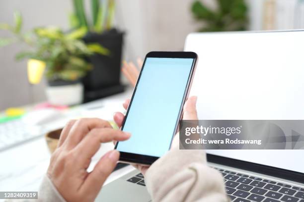 hand of woman holding smartphone, mobile phone blank screen - addiction mobile and laptop stockfoto's en -beelden