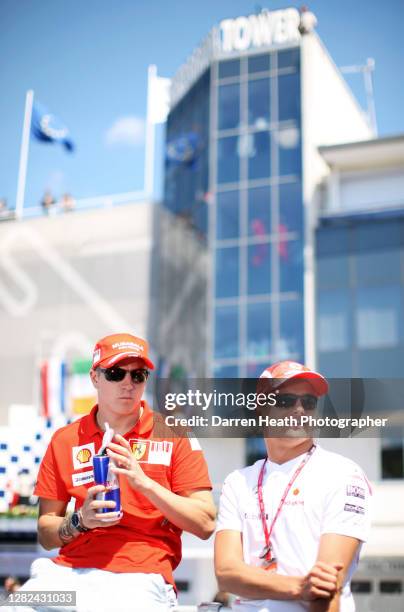 Finnish Ferrari Formula One driver Kimi Raikkonen sits alongside Finnish McLaren driver Heikki Kovalainen during the Drivers' Parade before the 2008...
