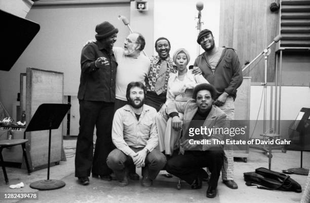 American soul and gospel singer songwriter, pianist, and civil rights activist Aretha Franklin poses for a portrait with members of her studio band...
