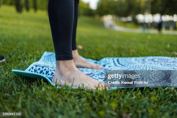 close up-handsome fit male is doing yoga in public park - male feet imagens e fotografias de stock