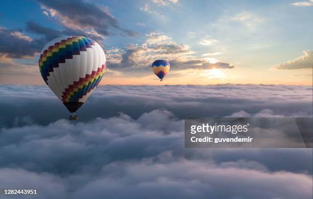 colorido globo aerostático volando por encima de las nubes - height fotografías e imágenes de stock