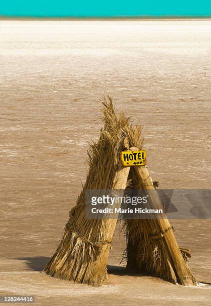 tee-pee like structure made with leaves of palm trees with yellow three star hotel sign located on salt flats on the way to tzour, tunisia - tunisia hotel stock pictures, royalty-free photos & images