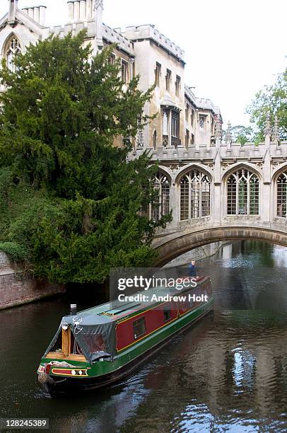 a narrowboat sailing under the bridge of sighs and past st john's college, cambridge. the bridge of sighs in cambridge is a bridge belonging to st. john's college of cambridge university. it was built in 1831 and crosses the river cam between the college' - st john's college stockfoto's en -beelden