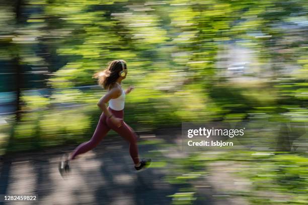 young sporty woman jogging through the forest. - norway womens training session stock pictures, royalty-free photos & images