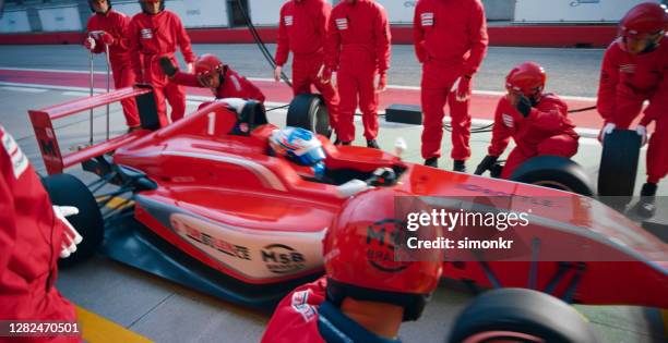 membri dell'equipaggio dei box che lavorano al pit stop - pit stop foto e immagini stock