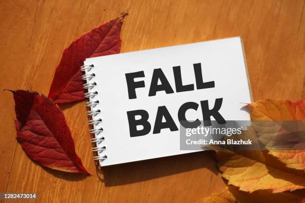 fall back concept. note pad with text. concept of time change due to daylight saving time on the 1st sunday of november. - daylight savings spring forward stock pictures, royalty-free photos & images