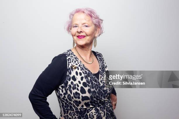 excentrieke hogere vrouw met roze haar dat glimlacht - luipaardprint stockfoto's en -beelden