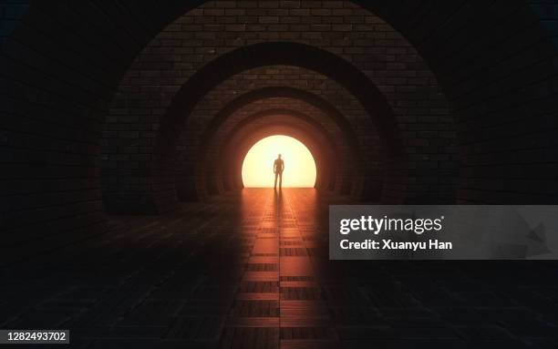 man standing in empty futuristic passage - stone arch stock pictures, royalty-free photos & images