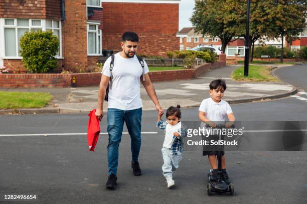 crossing the road safely with my boys - asian father stock pictures, royalty-free photos & images