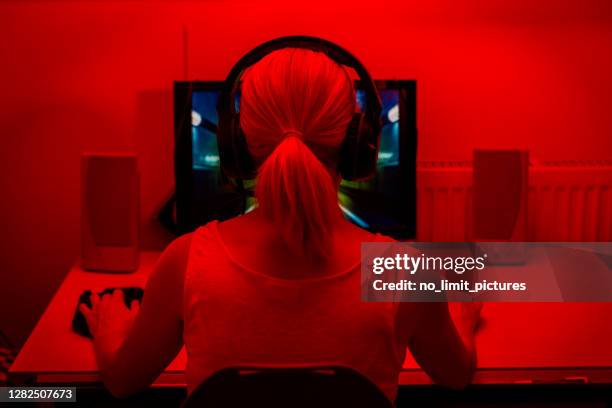 rear view of a young woman playing computer games - tank top back stock pictures, royalty-free photos & images