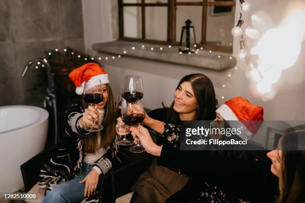 les amis trinquent avec un verre de vin rouge pendant les vacances de noël - apero noel photos et images de collection