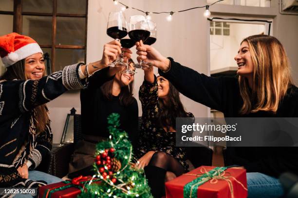 les amis trinquent avec un verre de vin rouge pendant les vacances de noël - apero noel photos et images de collection