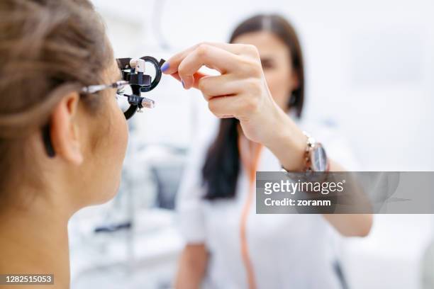 女性眼科醫生用光管測試患者的視力 - lens optical instrument 個照片及圖片檔