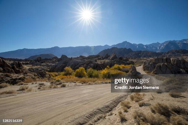 a dirt road leading through alabama hills. - hill range stock pictures, royalty-free photos & images
