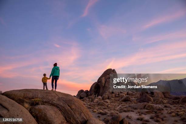 a woman and her son taking in a scenic view of sunset over the alabama hills - lone pine california - fotografias e filmes do acervo