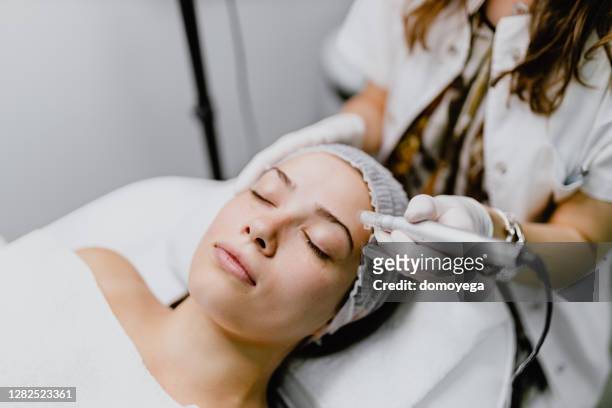 mujer joven que tiene una terapia de inducción de colágeno - beauty treatment fotografías e imágenes de stock