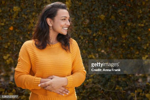 portrait of beautiful happy woman in a yellow jumper - touching stock pictures, royalty-free photos & images