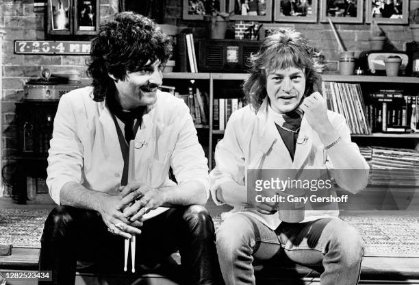 View of American Rock musicians Carmine Appice , who holds a pair of drumsticks, and Rick Derringer, who holds an MTV mug, both of the group DNA, as...