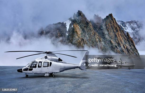 helicóptero y hélice avión en el apron de estacionamiento en fondos de montañas cubiertas de nieve - helicóptero fotografías e imágenes de stock