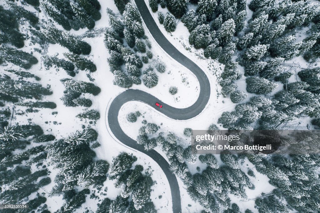 Aerial view of winding road in winter forest