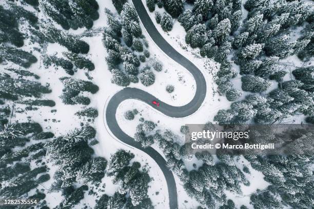 aerial view of winding road in winter forest - winding road imagens e fotografias de stock