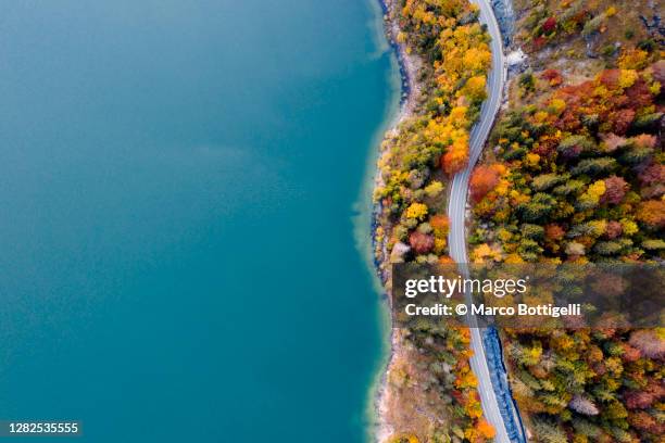 winding coastal road on turquoise colored lake - empty road above stock pictures, royalty-free photos & images