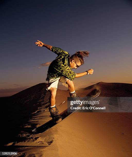 young man sandboarding - sand boarding stock pictures, royalty-free photos & images