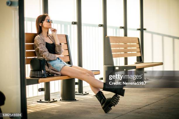 jonge vrouw die op trein wacht om op het platform bij spoorwegpost aan te komen - women wearing short skirts stockfoto's en -beelden
