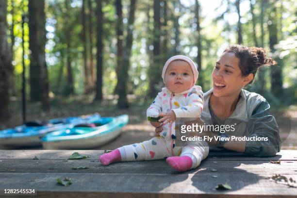 junge eurasische mutter und ihr baby camping - baby boot stock-fotos und bilder